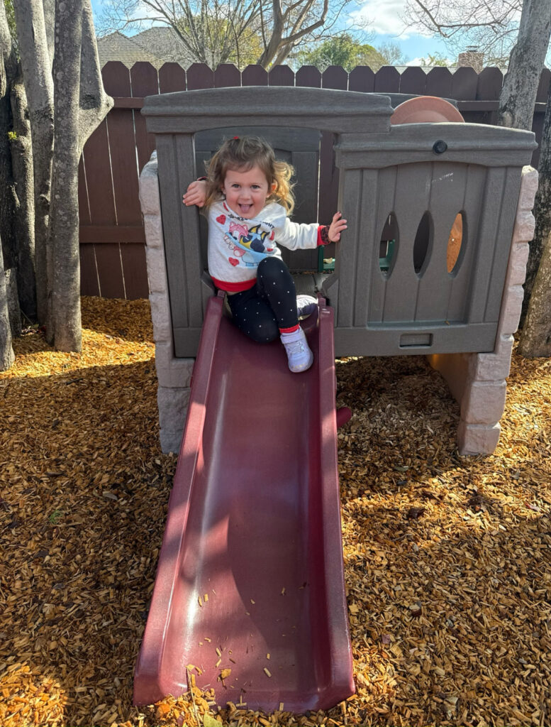 little girl on a small slide at Yellow Brick Road Preschool in Napa